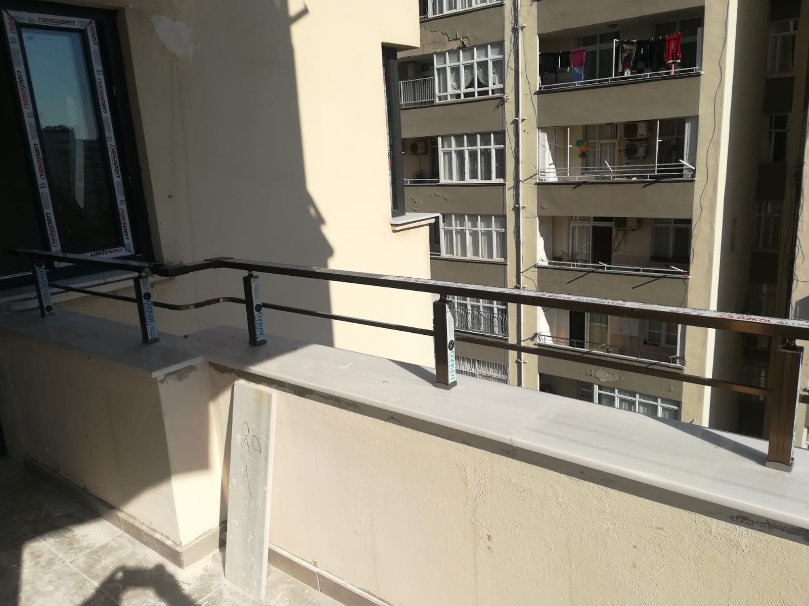 Konut balkonunda iki sıra yatay metal korkuluk