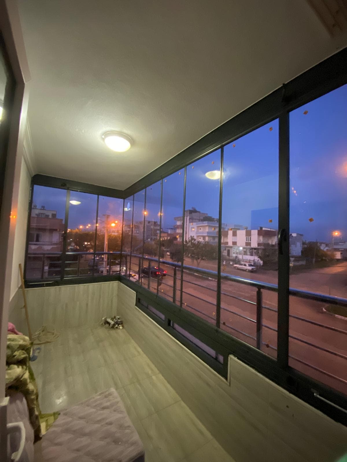 Akşam ışığında koyu profilli camlarla çevrili balkon