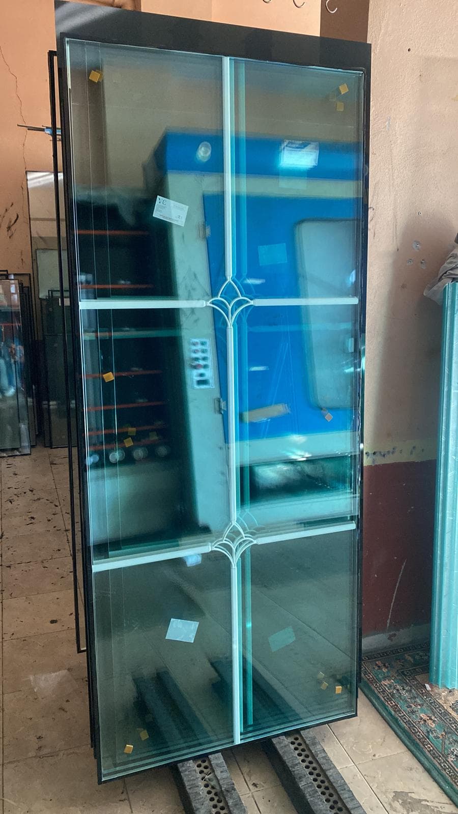 Atölyede hazırlanan mavi koruyucu filmli cam panel