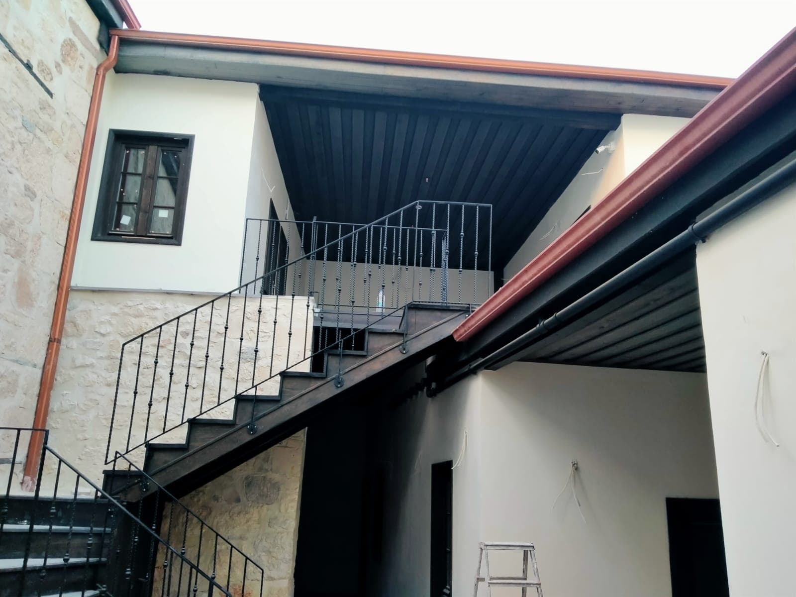 Üst örtü altındaki dış merdiven ve metal korkuluk