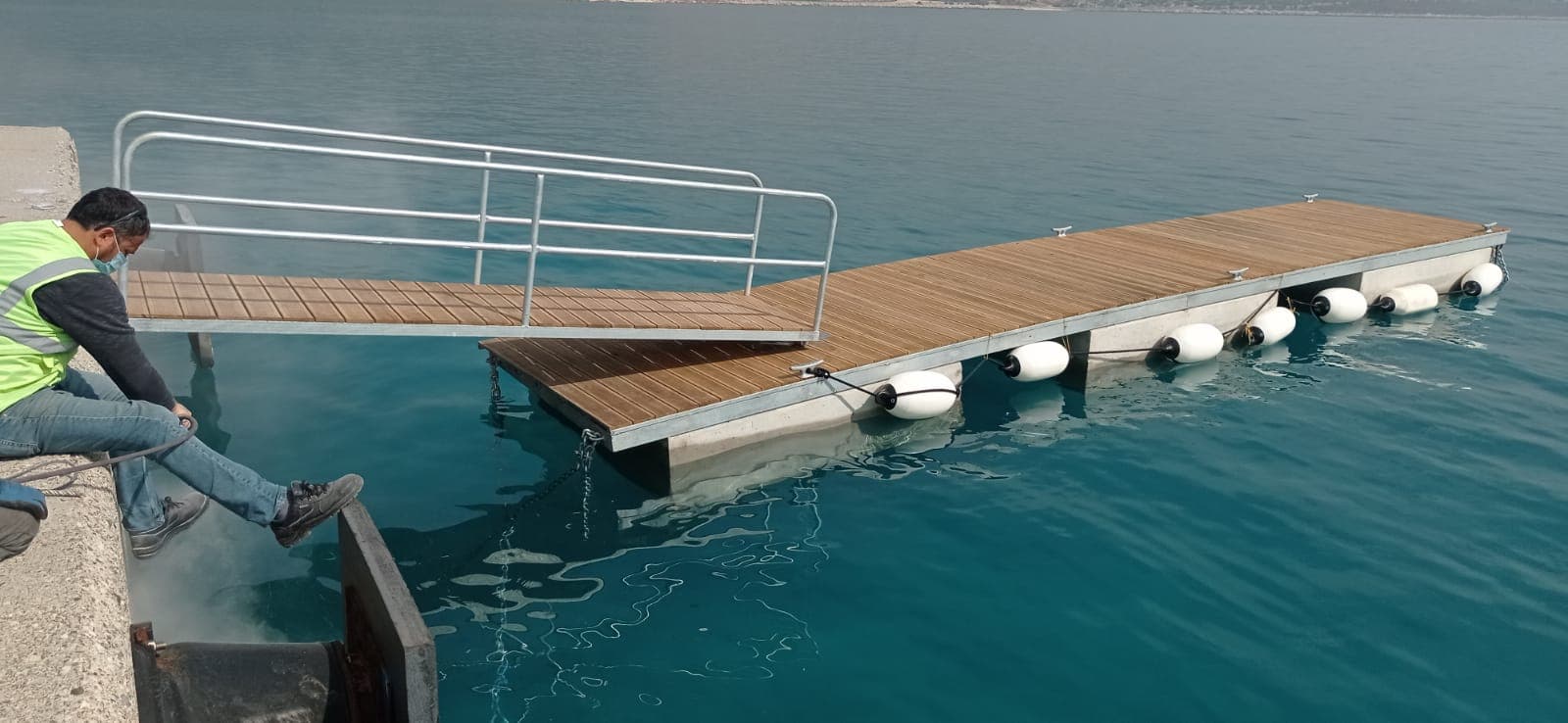 Su kenarında metal korkuluklu yüzer iskele