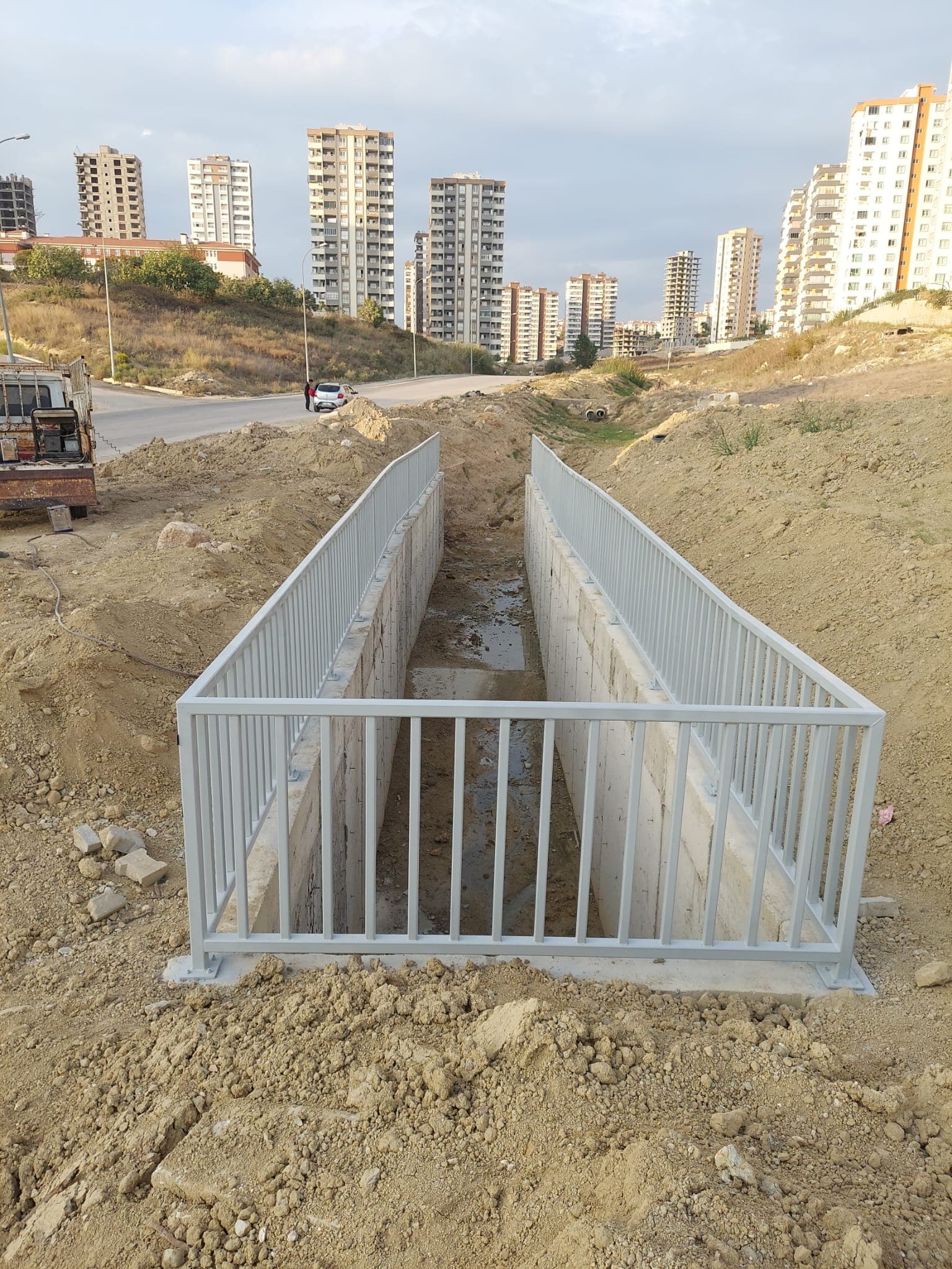 Açık kanalı çevreleyen açık renk metal korkuluklar