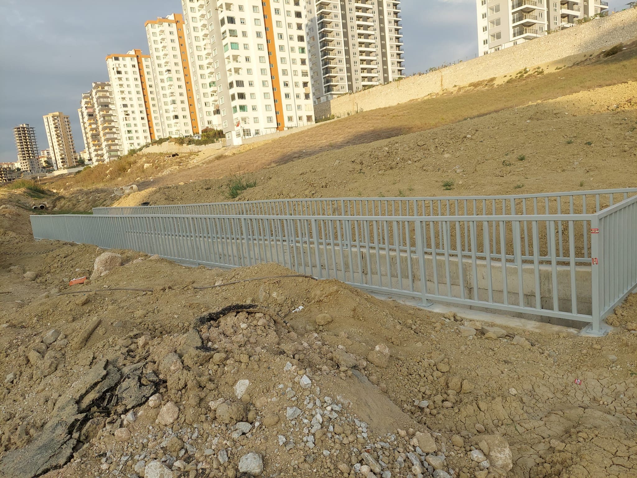 Kanal kenarındaki uzun metal korkuluğun yandan görünümü