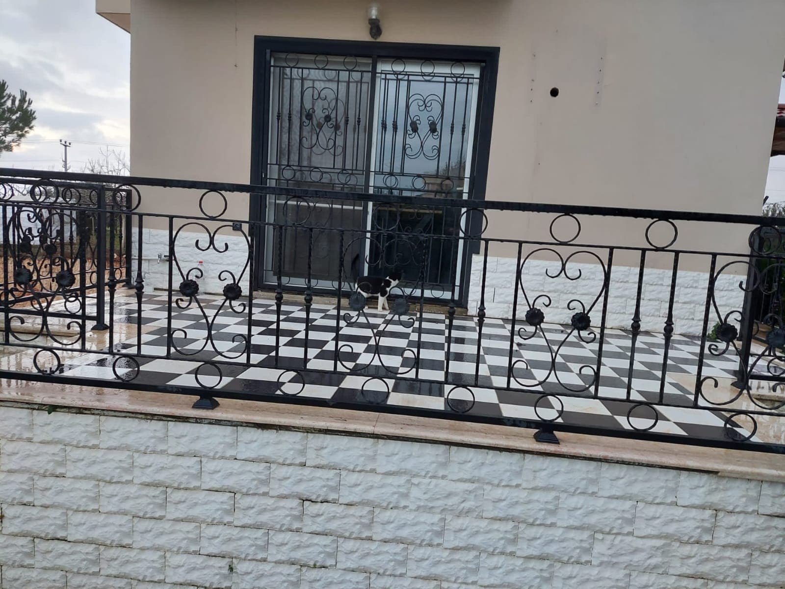 Konut verandasında çiçek desenli ferforje korkuluk