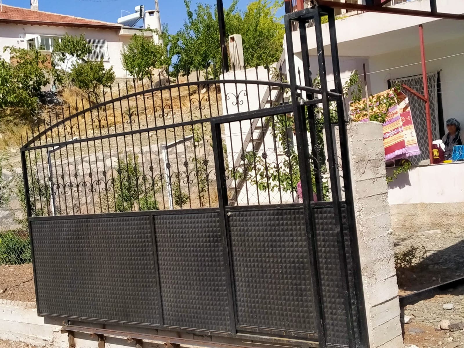 Üstü süslemeli altı kapalı büyük metal bahçe kapısı