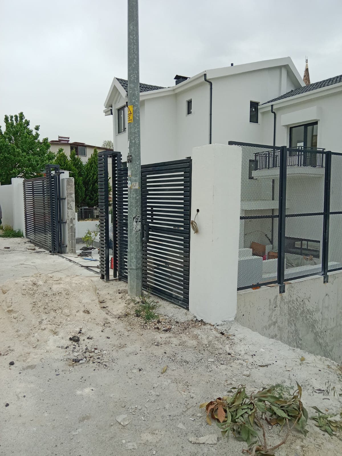 Konut çevresinde metal bahçe kapısı ve çit panelleri