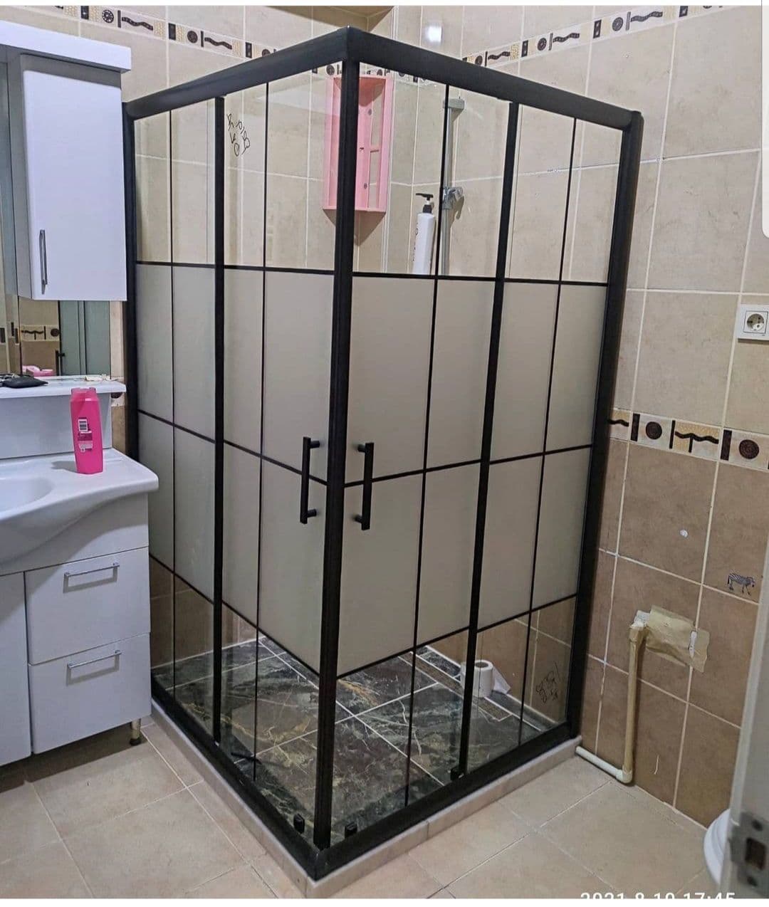 Kare bölümlü siyah profillerle çevrili köşe duşakabin