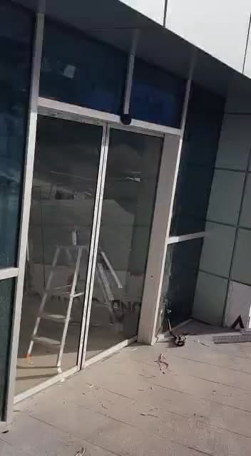 Montaj merdiveni önündeki yüksek cam giriş cephesi