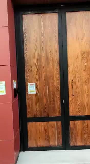 Ahşap görünümlü çift kanat ve duvar üzerindeki buton