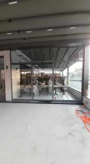Geniş ticari alanın cam girişindeki montaj çalışması