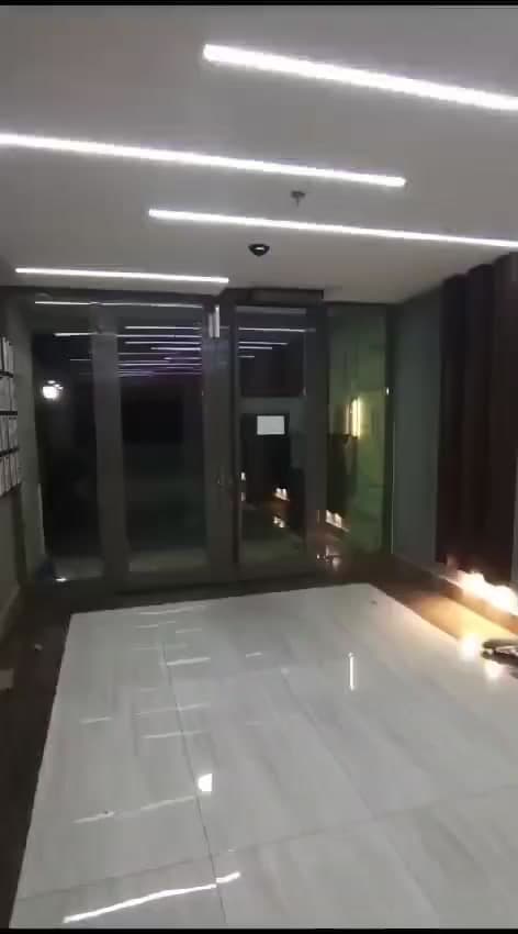 Tavan ışıkları altında koyu çerçeveli cam giriş