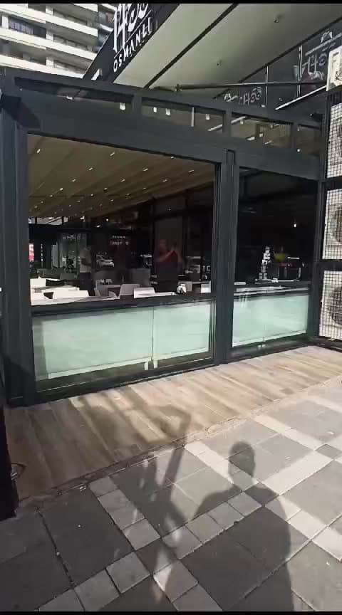 Köşe birleşimli cam paneller ve kafenin açık ön cephesi