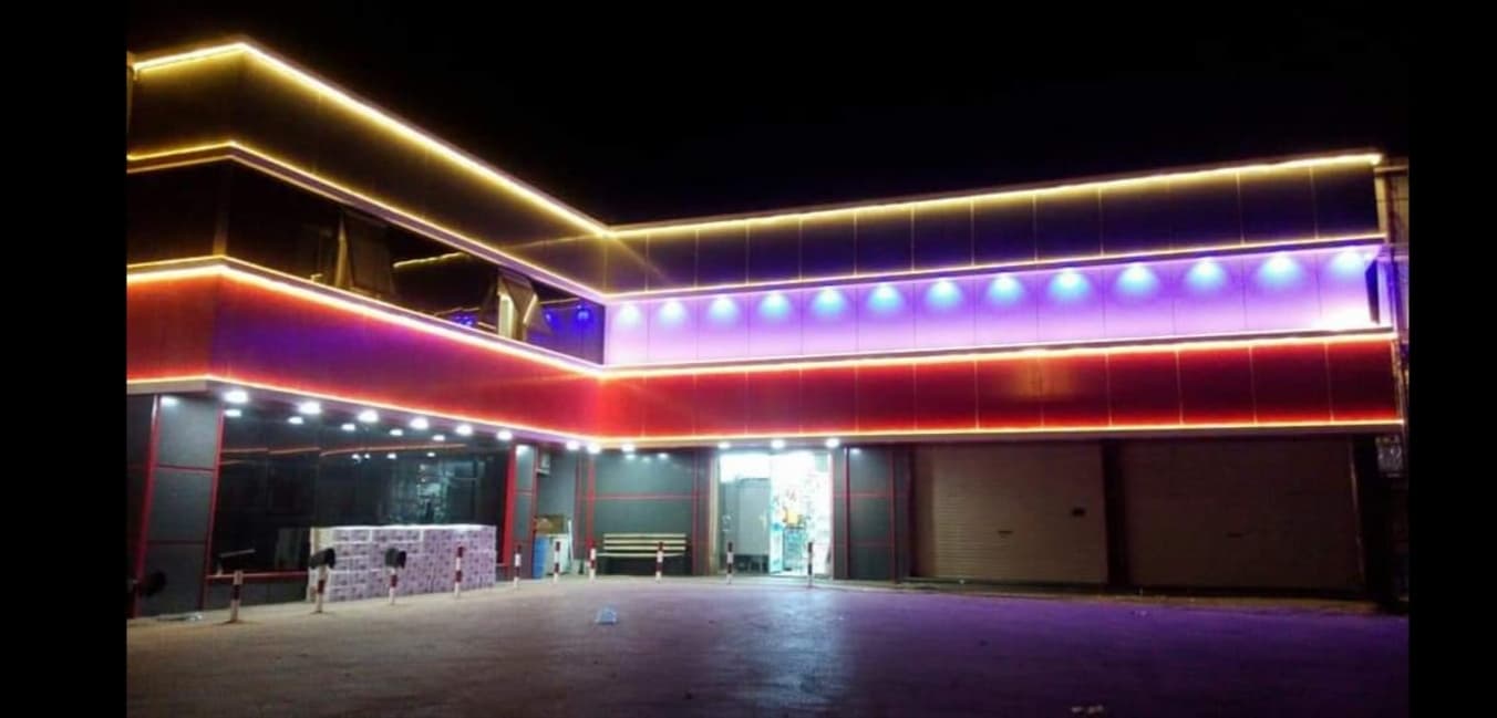 Gece aydınlatmalı geniş ticari cephe ve giriş alanı