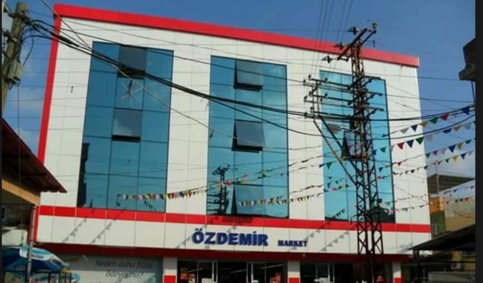 Mavi cam ve açık renk panellerle kaplı bina cephesi