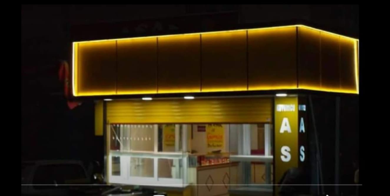 Sarı ışık çizgisiyle çevrelenmiş küçük iş yeri cephesi