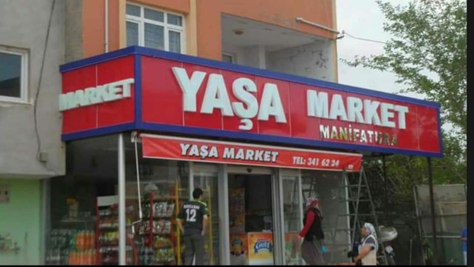 Köşe market girişindeki kırmızı tabela ve kaplama