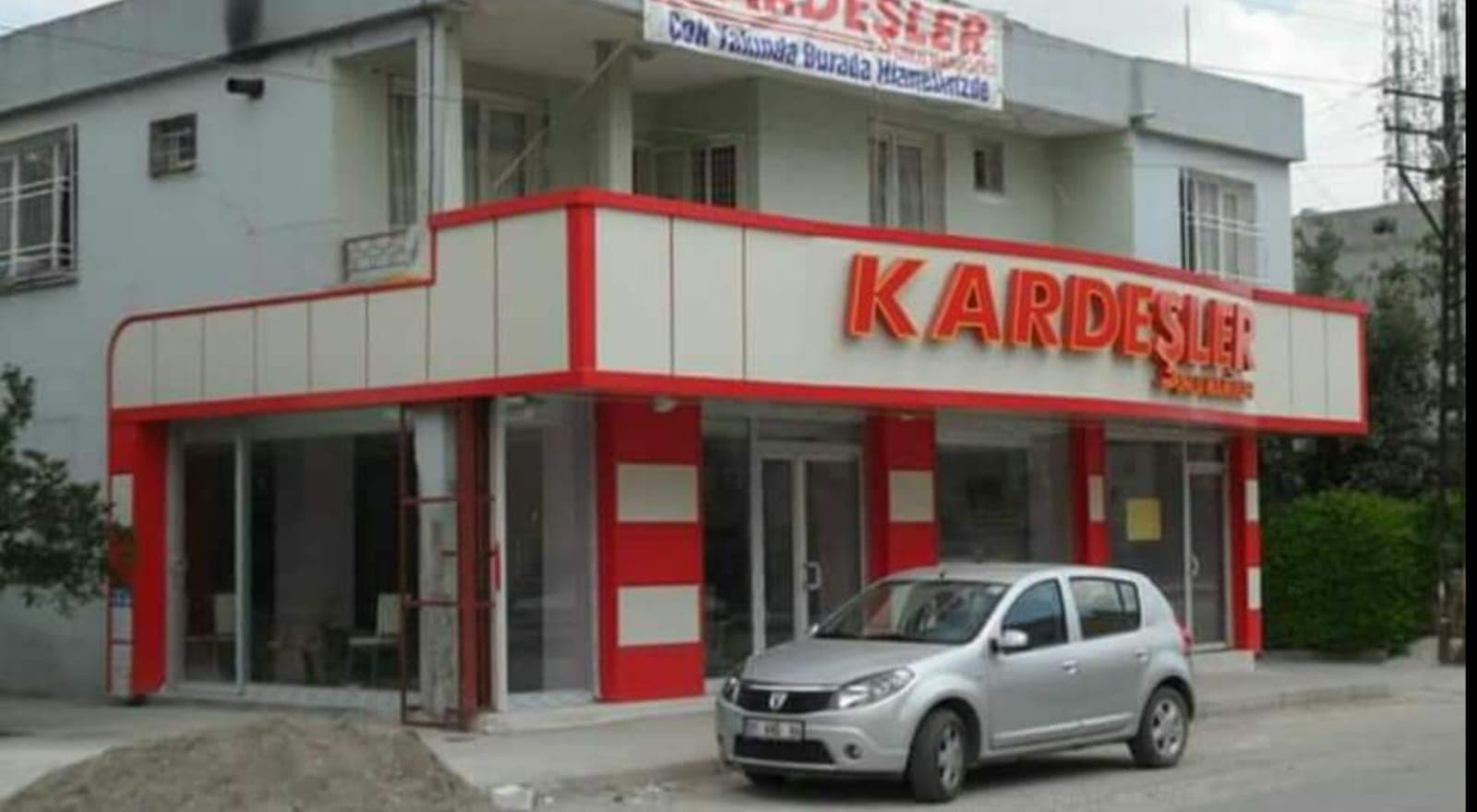 Açık renk paneller ve kırmızı detaylı mağaza cephesi