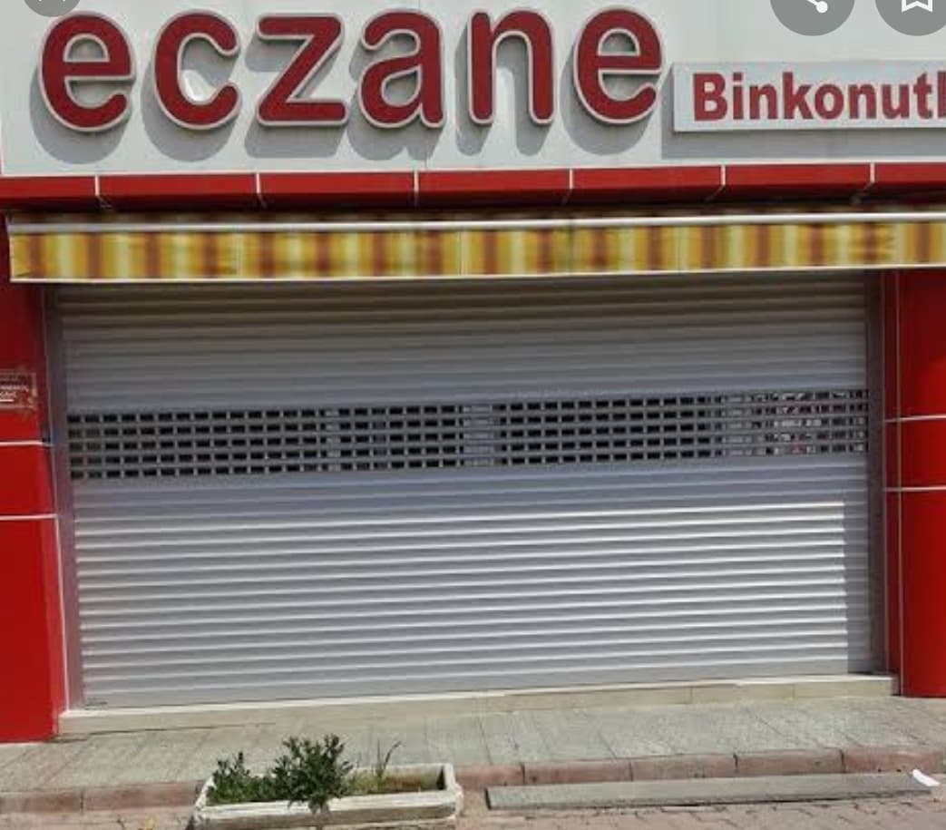 Eczane cephesinde delikli üst bantlı gri kepenk