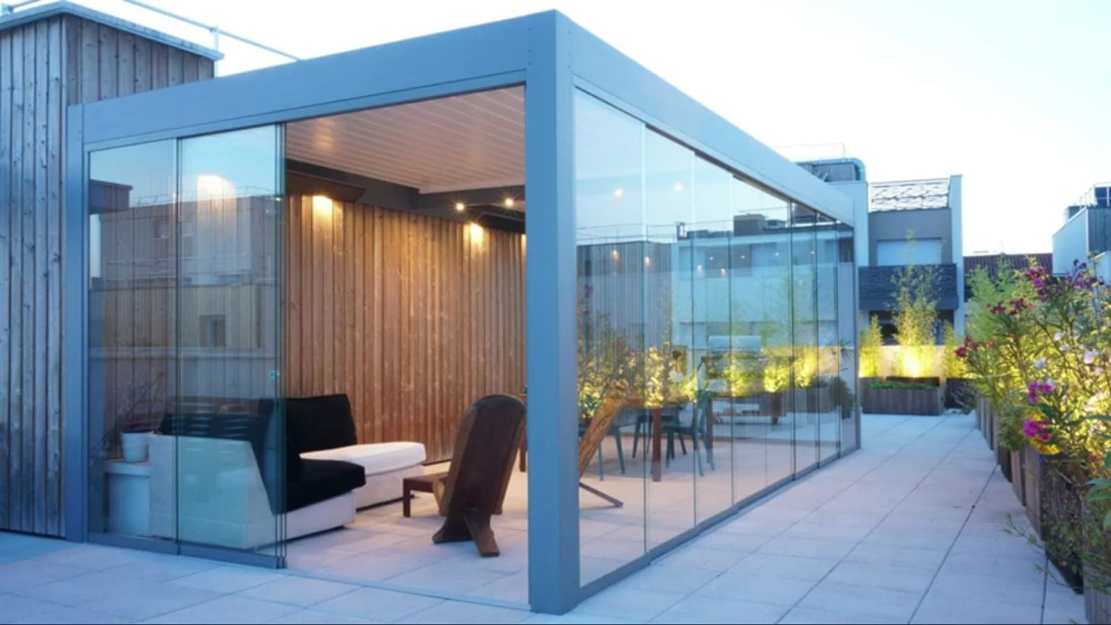 Çatı terasında cam panellerle çevrili oturma alanı