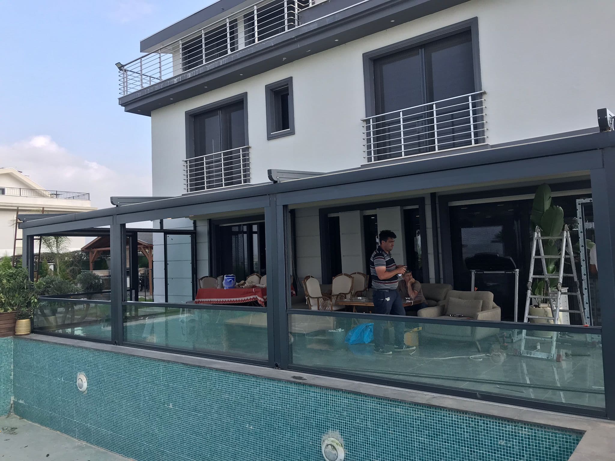 Havuz kenarındaki konutta pergola ve cam panel uygulaması