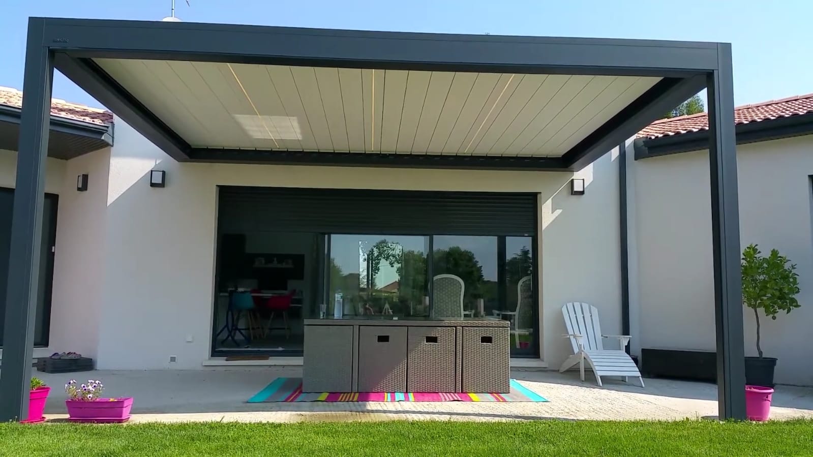 Konut bahçesinde kapalı lamelli pergola ve oturma grubu